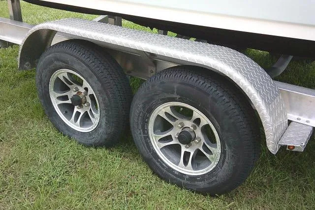 Slide: The Image of Trailer wheels of a 2020 Stingray 216 CC boat on grass. - 10