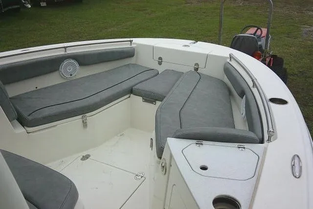 Slide: The Image of 2020 Stingray 216 CC boat interior with gray cushioned seating and storage compartments. - 11