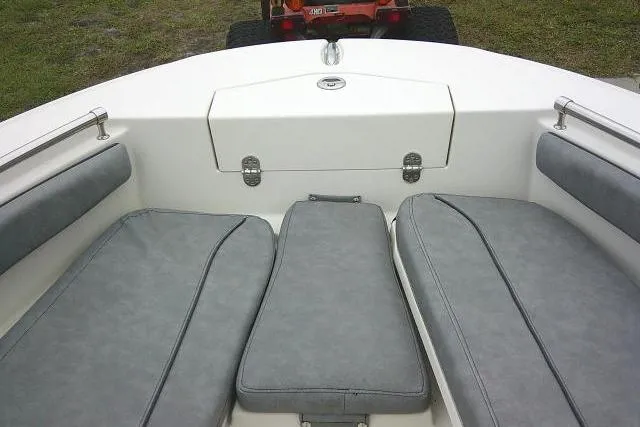 Slide: The Image of 2020 Stingray 216 CC boat interior with gray cushioned seating and storage compartment. - 12