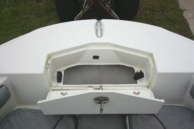 Slide: The Image of 2020 Stingray 216 CC boat storage compartment with open hatch, showing interior space. - 13