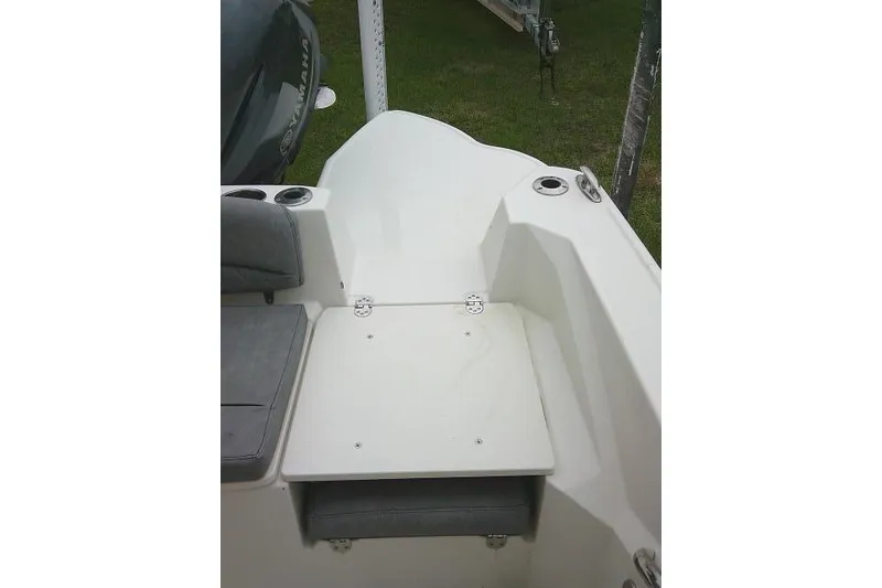 Slide: The Image of 2020 Stingray 216 CC boat interior with seating and cup holders, viewed from the rear. - 25