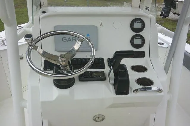 Slide: The Image of 2020 Stingray 216 CC boat console with steering wheel, Garmin display, and controls. - 28