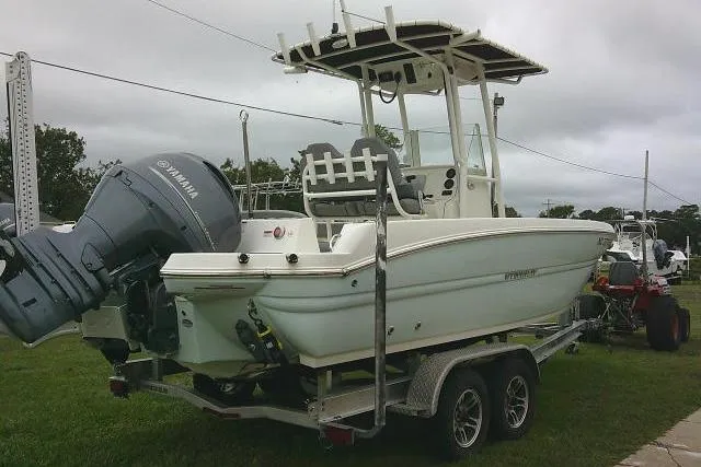 Slide: The Image of 2020 Stingray 216 CC boat on trailer with Yamaha outboard motor, parked on grass. - 4