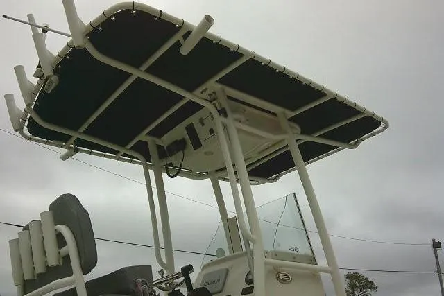 Slide: The Image of 2020 Stingray 216 CC boat with T-top and rod holders under cloudy sky. - 8