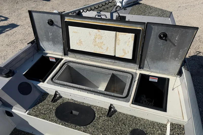 Slide: The Image of 2013 G3 1860 CC Deluxe boat with open storage compartments and carpeted deck. - 18