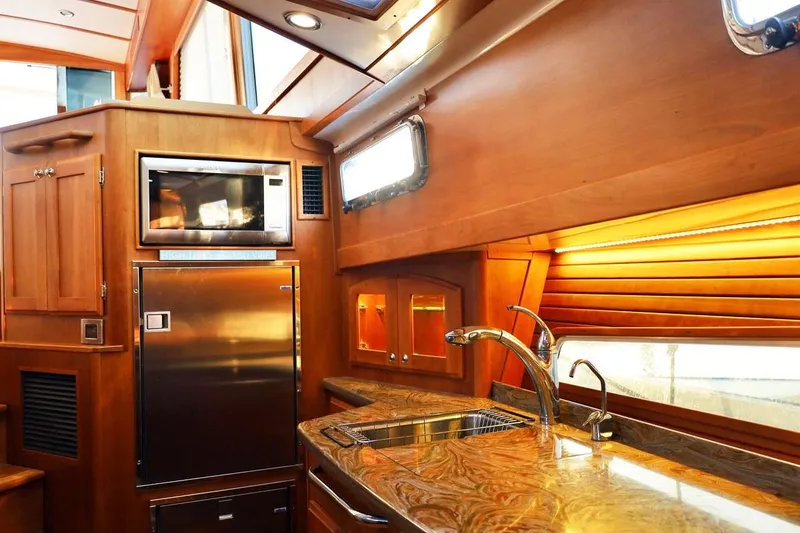 Slide: The Image of Luxurious kitchen interior of 2018 Sabre 48 Flybridge Sedan yacht with wood finish. - 11