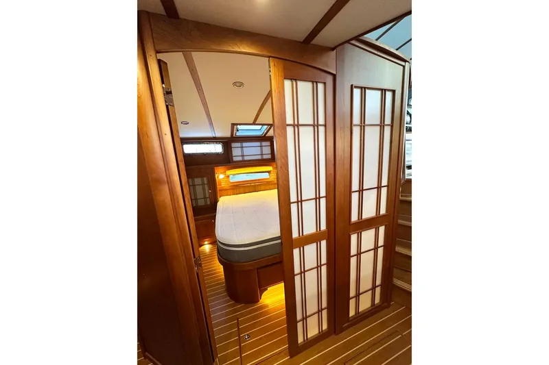 Slide: The Image of Interior of 2018 Sabre 48 Flybridge Sedan with wooden sliding doors and cozy bedroom. - 14