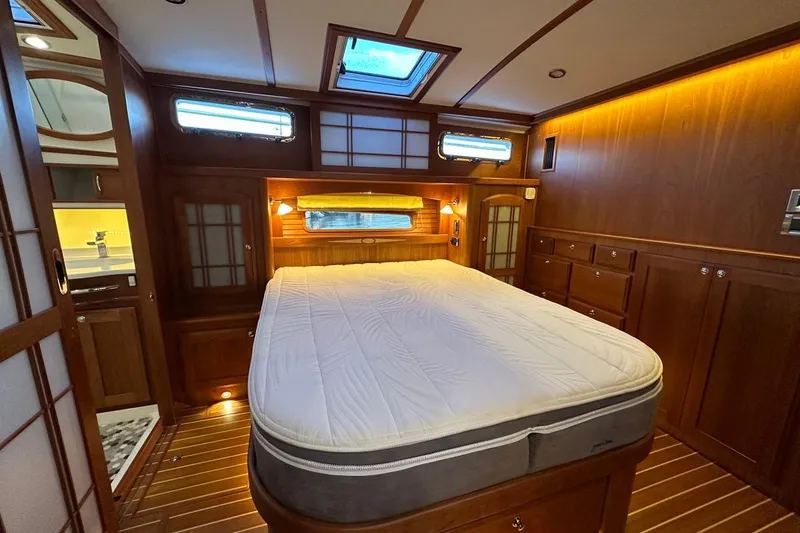 Slide: The Image of Luxurious 2018 Sabre 48 Flybridge Sedan bedroom with wood paneling and skylight. - 16