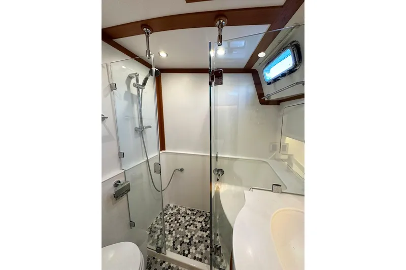 Slide: The Image of Luxurious bathroom in 2018 Sabre 48 Flybridge Sedan yacht with glass shower enclosure. - 20