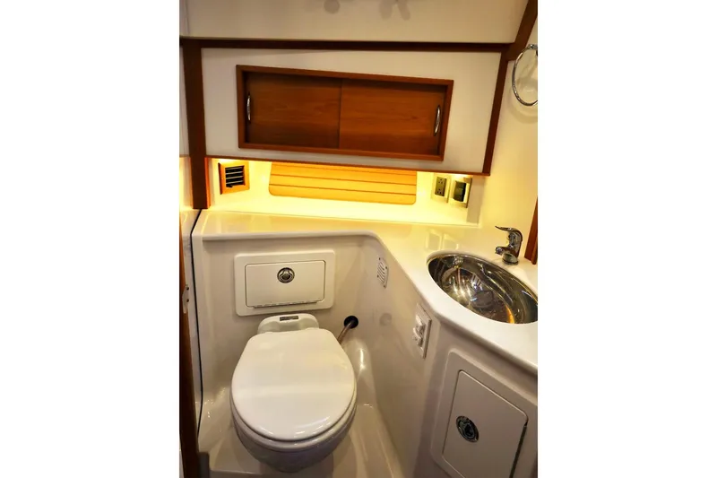Slide: The Image of 2018 Sabre 48 Flybridge Sedan bathroom with modern fixtures and wooden cabinetry. - 23
