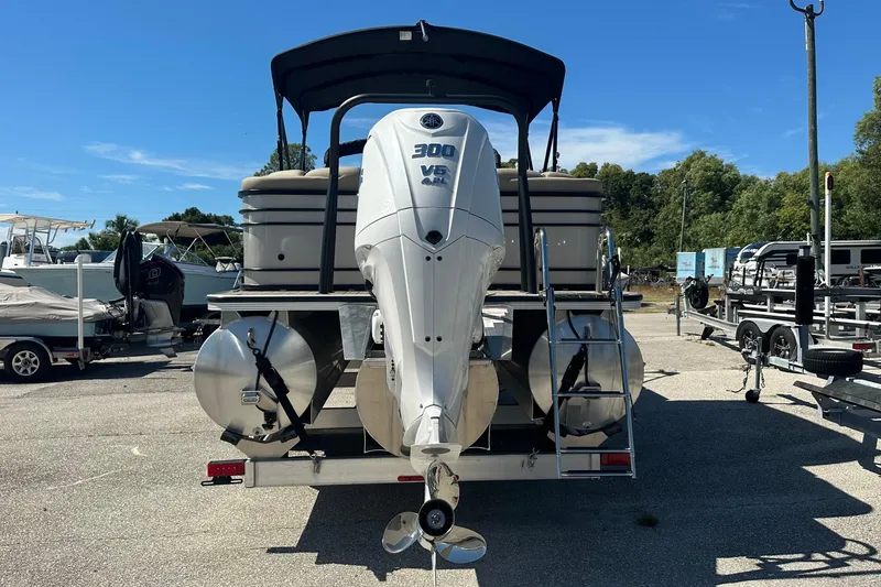 Slide: The Image of 2024 Veranda VP 25RC pontoon boat with powerful 300 HP engine, parked outdoors. - 10