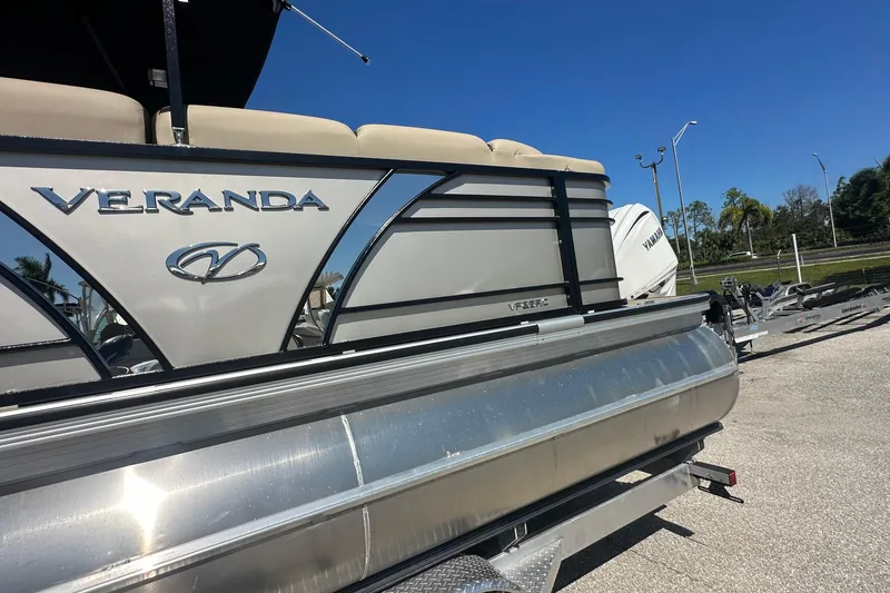 Slide: The Image of 2024 Veranda VP 25RC pontoon boat on trailer, sunny day, clear blue sky. - 12