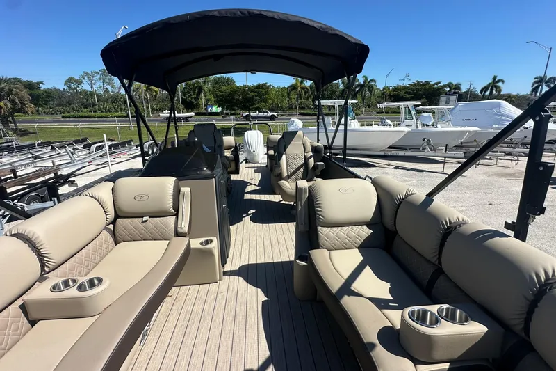 Slide: The Image of 2024 Veranda VP 25RC pontoon boat with luxurious seating and canopy, docked outdoors. - 4