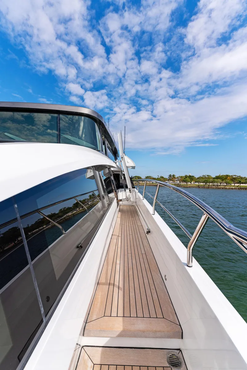 Slide: The Image of Side deck view of 2020 Mangusta 109 yacht under a blue sky. - 26