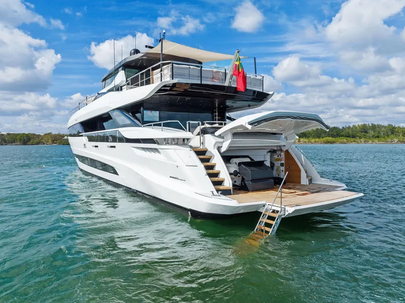 Slide: The Image of 2020 Mangusta 109 yacht on water, rear view with open garage and swim ladder. - 4