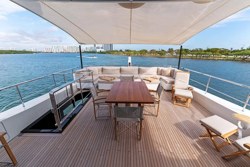 Slide: The Image of Spacious deck of 2020 Mangusta 109 yacht with seating and dining area, overlooking serene waters. - 6