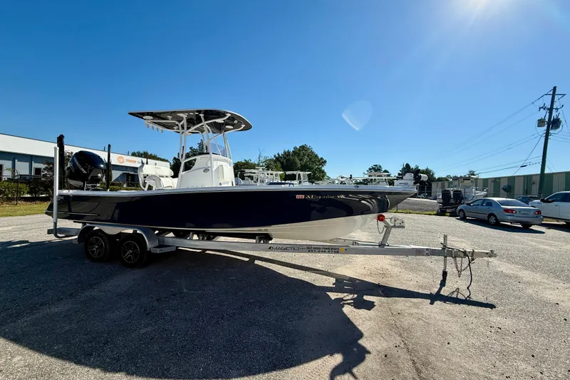 Slide: The Image of 2021 BlackJack 256 Bay boat on trailer under clear blue sky. - 10