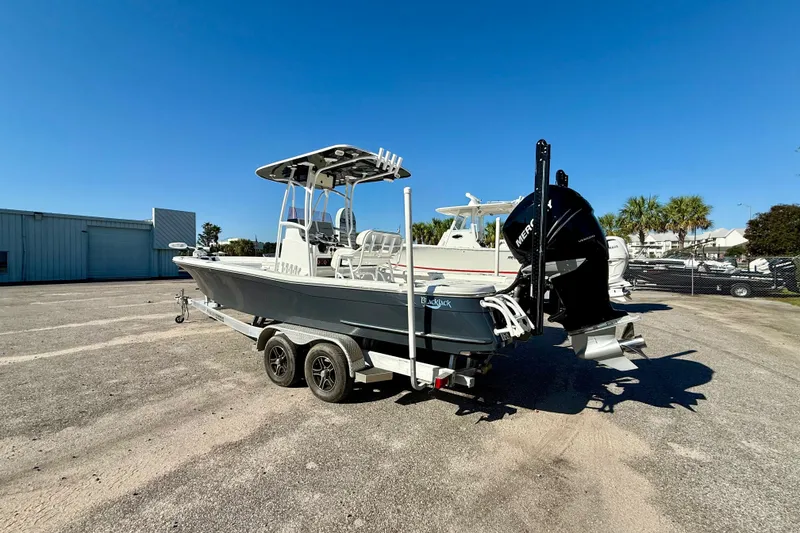 Slide: The Image of 2021 BlackJack 256 Bay boat on trailer, parked outdoors under clear blue sky. - 12