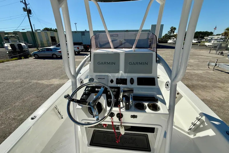 Slide: The Image of 2021 BlackJack 256 Bay boat dashboard with Garmin navigation systems and steering wheel. - 18