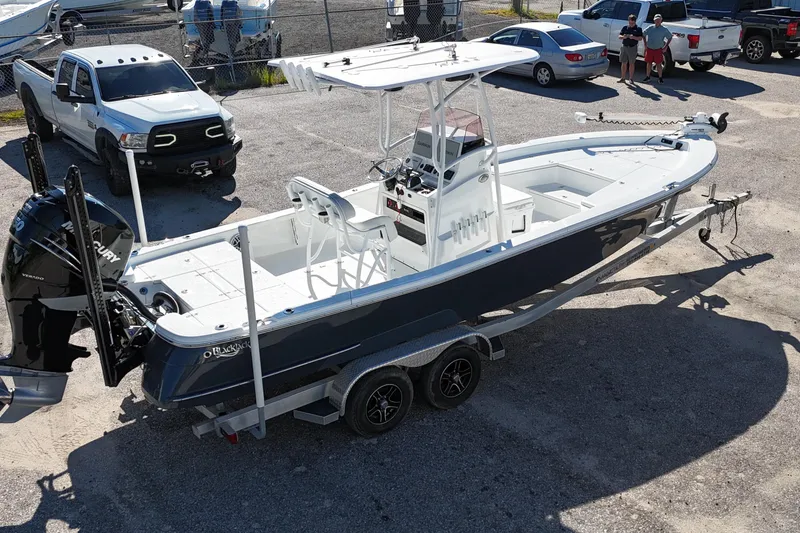 Slide: The Image of 2021 BlackJack 256 Bay boat on trailer, parked near vehicles in a lot. - 3