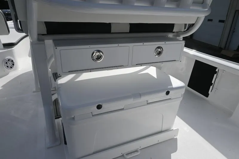 Slide: The Image of 2026 Tidewater 2210 Carolina Bay boat interior with storage compartments and cooler. - 22