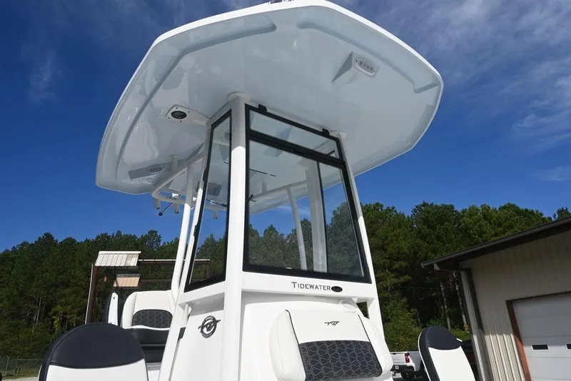 Slide: The Image of 2026 Tidewater 2210 Carolina Bay boat with T-top against blue sky and trees. - 23