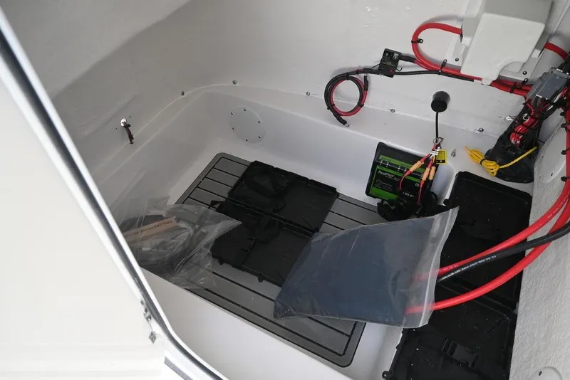 Slide: The Image of Interior view of 2026 Tidewater 2210 Carolina Bay boat compartment with wiring and storage. - 26