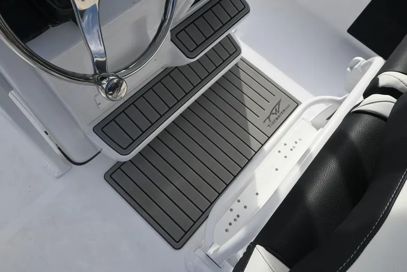 Slide: The Image of 2026 Tidewater 2210 Carolina Bay boat interior with steering wheel and branded floor mat. - 9