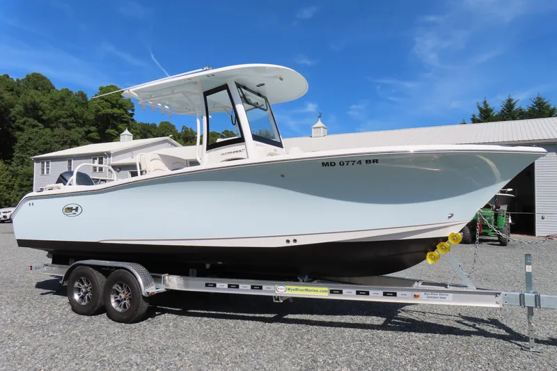 Slide: The Image of 2020 Sea Hunt Ultra 255 SE boat on trailer, parked outdoors under clear blue sky. - 0