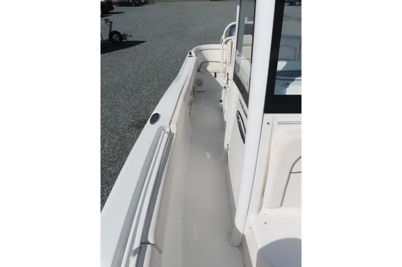 Slide: The Image of 2020 Sea Hunt Ultra 255 SE boat deck, featuring sleek white design and spacious walkway. - 17