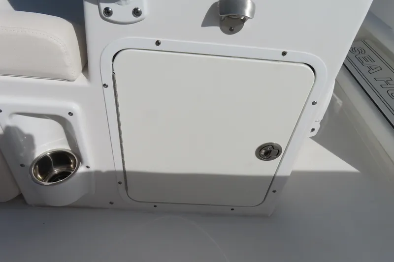 Slide: The Image of 2020 Sea Hunt Ultra 255 SE boat storage compartment with cup holder. - 28