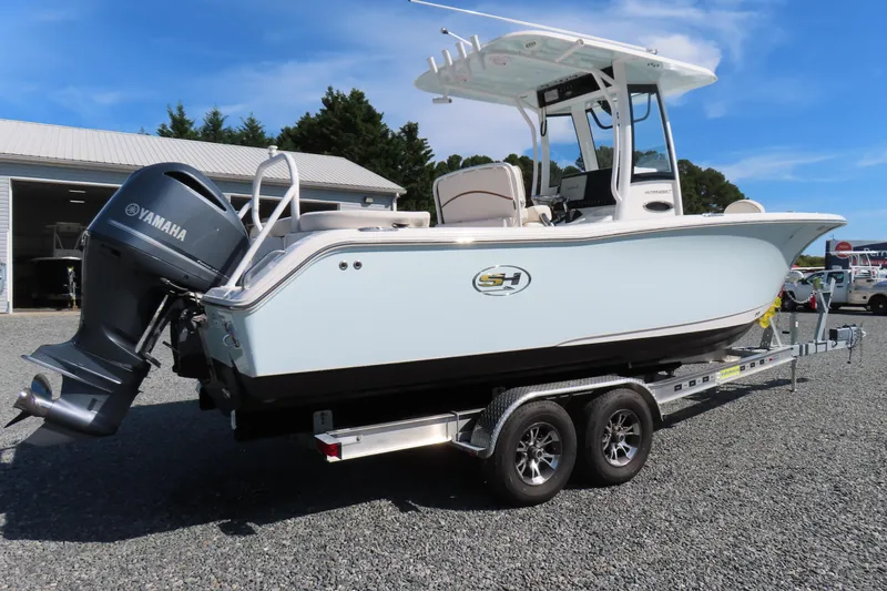 Slide: The Image of 2020 Sea Hunt Ultra 255 SE boat on trailer with Yamaha engine, parked outdoors. - 3