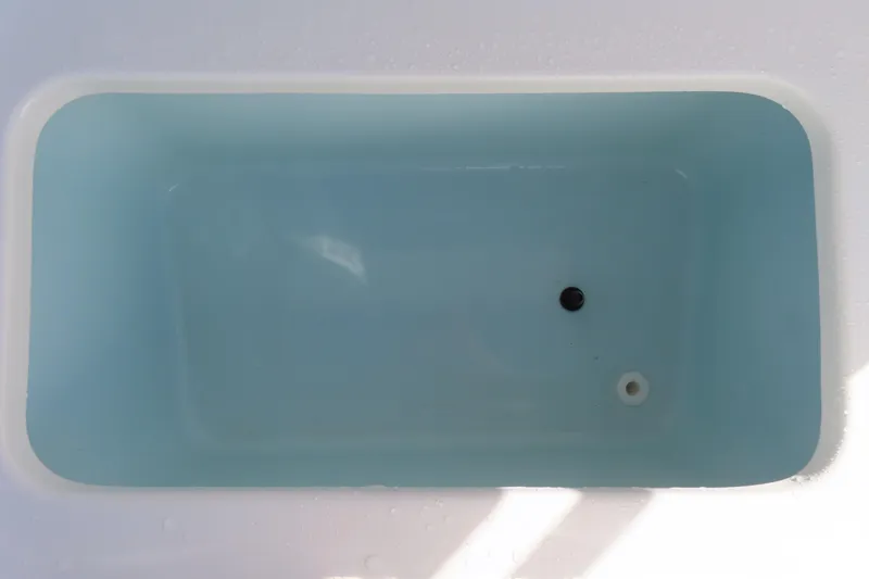 Slide: The Image of Livewell compartment on a 2020 Sea Hunt Ultra 255 SE boat, featuring a clean, blue interior. - 34