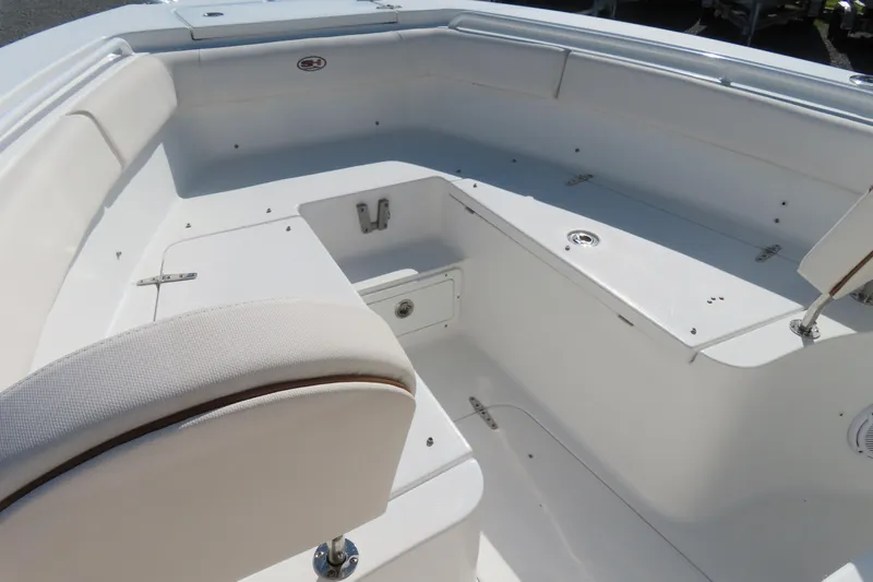 Slide: The Image of 2020 Sea Hunt Ultra 255 SE boat interior with white seating and storage compartments. - 9