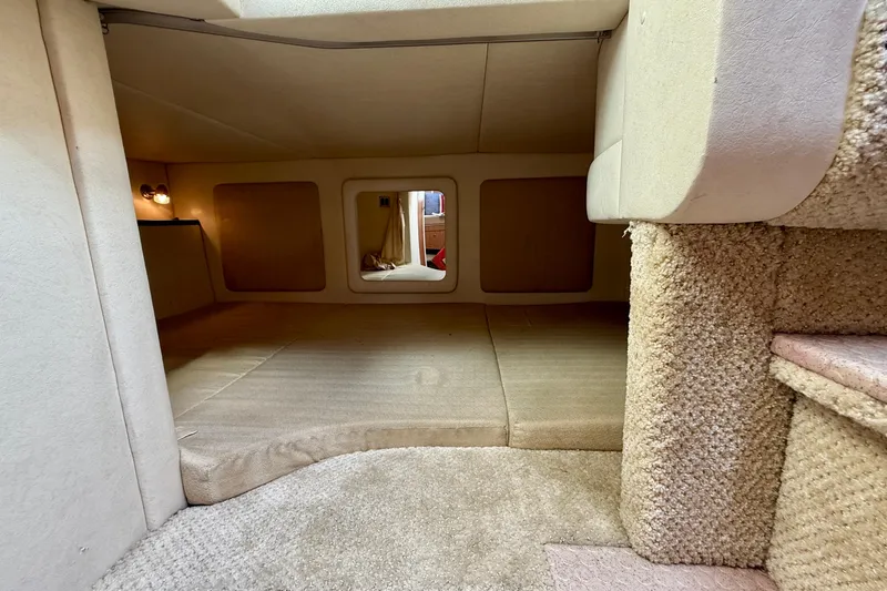 Slide: The Image of 2006 Sea Ray 290 Sundancer cabin interior with beige carpeting and cozy lighting. - 12