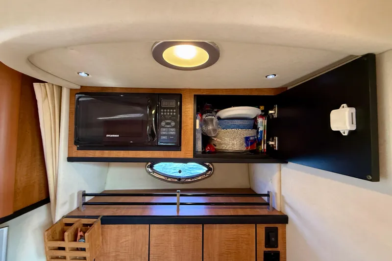 Slide: The Image of 2006 Sea Ray 290 Sundancer interior with microwave and storage cabinet. - 18