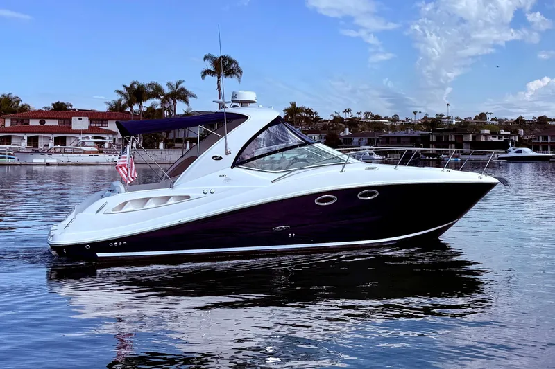 Slide: The Image of 2006 Sea Ray 290 Sundancer boat on calm water, with scenic background. - 2