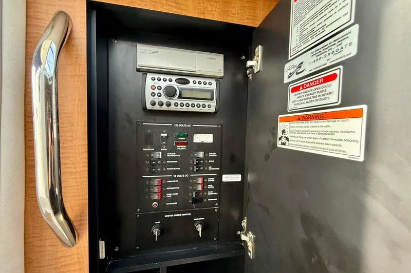 Slide: The Image of Electrical control panel inside 2006 Sea Ray 290 Sundancer boat with warning labels. - 20
