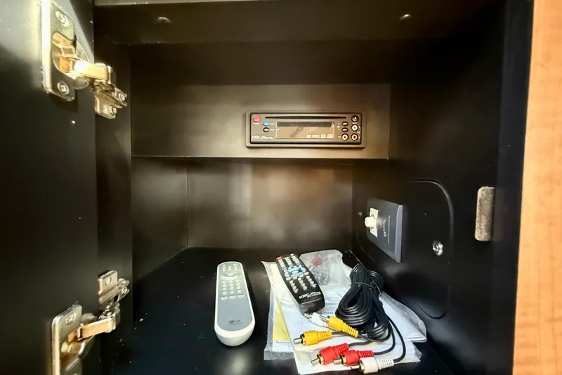 Slide: The Image of 2006 Sea Ray 290 Sundancer cabinet with stereo, remotes, and AV cables. - 21