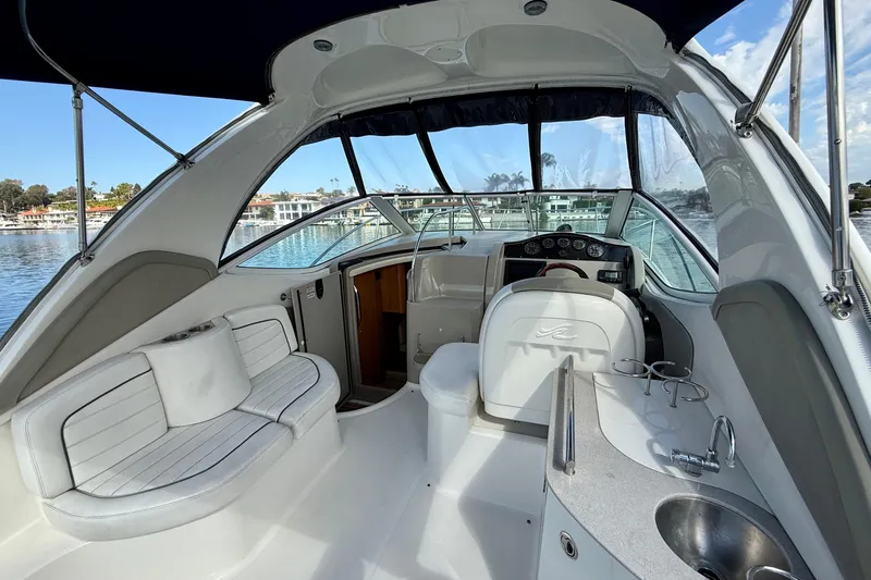 Slide: The Image of 2006 Sea Ray 290 Sundancer boat interior with helm, seating, and waterfront view. - 31