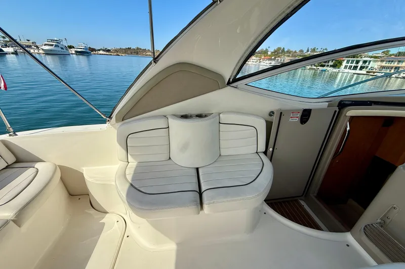 Slide: The Image of 2006 Sea Ray 290 Sundancer interior with white seating, docked in a marina. - 35