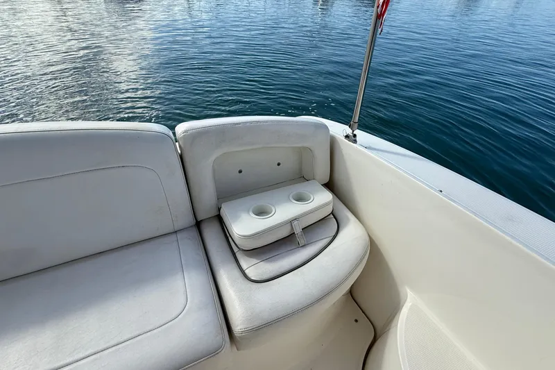Slide: The Image of 2006 Sea Ray 290 Sundancer boat interior with cushioned seating and cup holders. - 36