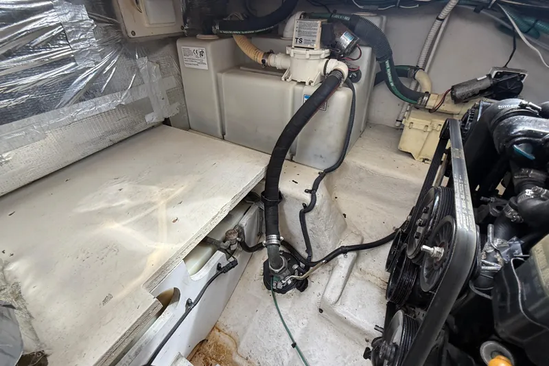 Slide: The Image of Engine compartment of a 2006 Sea Ray 290 Sundancer boat, showing mechanical components and hoses. - 43