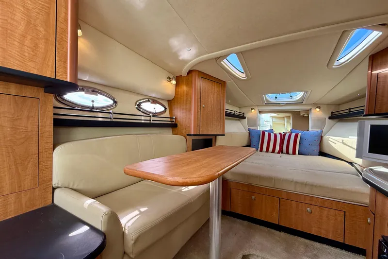 Slide: The Image of 2006 Sea Ray 290 Sundancer cabin interior with seating, table, and skylights. - 7
