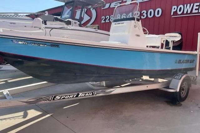 Slide: The Image of 2016 Blazer Bay 1960 boat on Sport Trail trailer, displayed outdoors. - 1