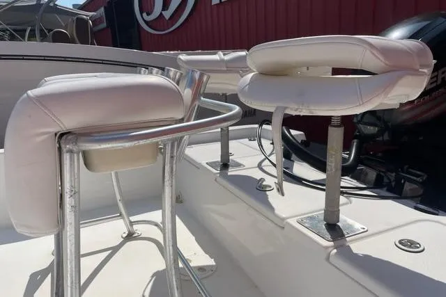 Slide: The Image of White leather boat seats on a 2016 Blazer Bay 1960, with metal frames and outdoor setting. - 5