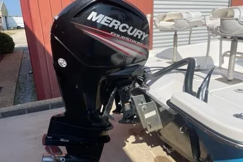 Slide: The Image of 2016 Blazer Bay 1960 boat with Mercury outboard motor, docked near a red building. - 9