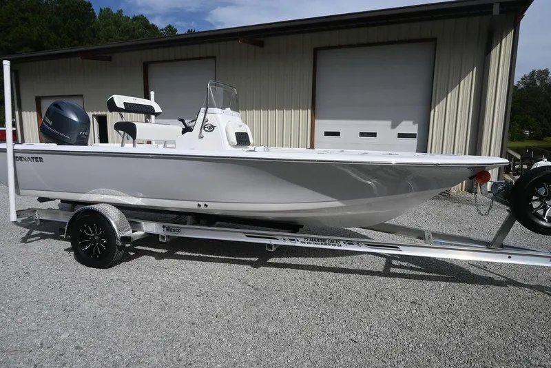 The Image of 2026 Tidewater 1910 Bay Max boat on trailer, parked outside a garage. - 1