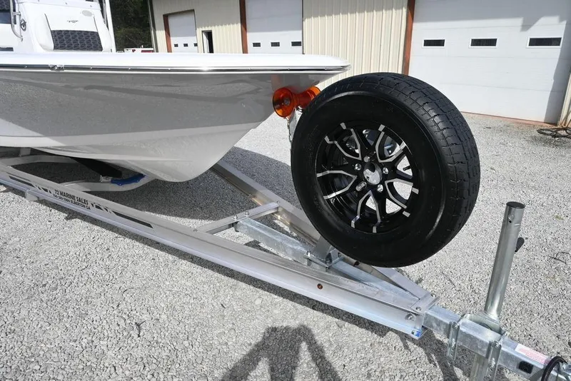 Slide: The Image of 2026 Tidewater 1910 Bay Max boat on trailer with spare tire, parked outside garage. - 8