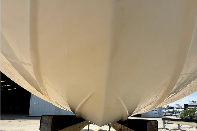 Slide: The Image of 2016 Chaparral 230 Suncoast boat hull, close-up view, displayed outdoors. - 10